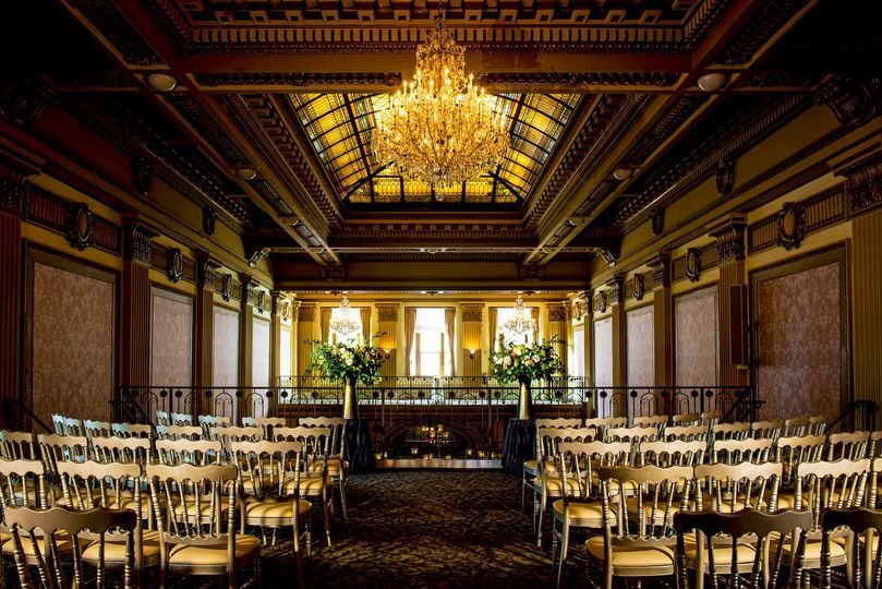 A room with chairs and chandelier.